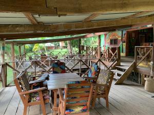 Cocoa Village Guesthouse في Obo: طاولة وكراسي خشبية على سطح خشبي