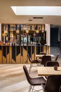 a restaurant with a bar with tables and chairs at Labirint Boutique Hotel in Bucharest