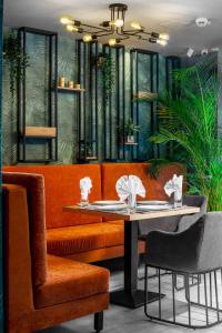 un restaurante con sofá naranja, mesa y sillas en Labirint Boutique Hotel, en Bucarest