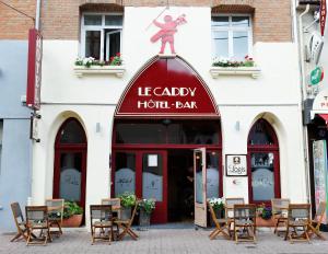 een restaurant met een rood bord aan de voorzijde van een gebouw bij Logis - Hôtel Le Caddy in Le Touquet-Paris-Plage