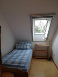 een kleine slaapkamer met een bed en een raam bij Gartenwohnung in Norden