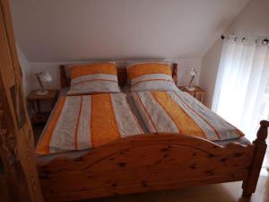 a bedroom with a wooden bed with two pillows at Gartenwohnung in Norden
