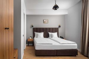 a bedroom with a large bed with white sheets at Labirint Boutique Hotel in Bucharest +40 photos