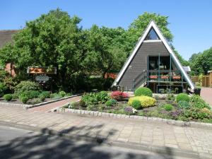 a small house with a garden in front of it at Ferienhaus Hubertus, 95059 in Rhauderfehn