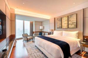 een hotelkamer met een groot bed en een stoel bij InterContinental Guangzhou Exhibition Center, an IHG Hotel - Free Canton Fair Shuttle Bus and Registration Counter in Guangzhou