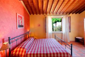 ein Schlafzimmer mit einem Bett mit einer karierten Decke in der Unterkunft Agriturismo Il Pelago in Castagneto Carducci