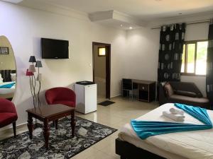 a bedroom with a bed and a living room at class hotel in Brazzaville