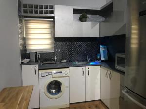 een keuken met een wasmachine en een wastafel bij Bari suite at Royal Park in Eilat