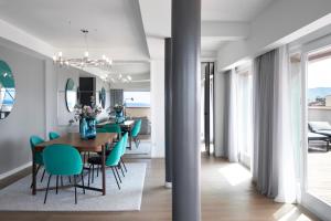 維亞雷焦的住宿－Hotel Plaza e de Russie - Relais & Châteaux，用餐室以及带桌椅的起居室。