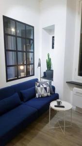 niebieską kanapę w salonie ze stołem w obiekcie JOIVY Heart of the City 1 Bed Apt near Castle Belvedere w Genui