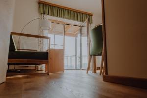a living room with a mirror and a green chair at Winzerhaus am Gamlitzberg in Gamlitz