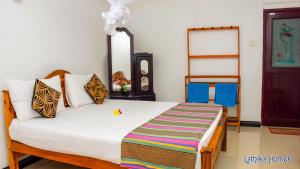 Un dormitorio con una cama con una manta a rayas. en Lathika Homes, en Sigiriya