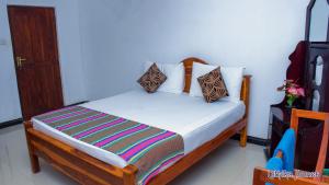 a bedroom with a bed with white sheets and pillows at Lathika Homes in Sigiriya