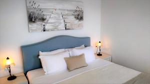 um quarto com uma cama com uma cabeceira azul e 2 candeeiros em Hotel Mylos em Firostefani