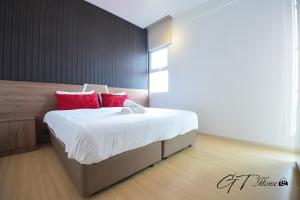 a bedroom with a large bed with red pillows at GT Home @ Sunway Nexis in Petaling Jaya