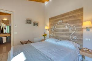- une chambre avec un grand lit et une tête de lit en bois dans l'établissement Agriturismo Corte Aurea, à Desenzano del Garda