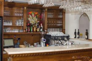 Brezová pod Bradlom的住宿－Penzión Tvarožek ***，一个带吧台的酒吧,配有瓶子和眼镜