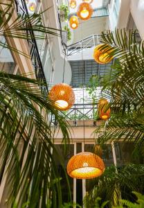 Ein paar Lichter hängen von einem Gebäude mit Palmen. in der Unterkunft Ohana Hotel in Hanoi