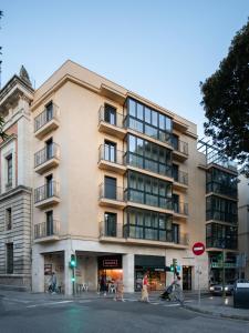 um edifício numa rua com pessoas a atravessar a rua em Slow Suites Setas em Sevilha