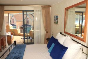 1 dormitorio con cama y vistas a una casa en 29 The Village en Hout Bay