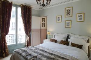 um quarto com uma cama grande e uma janela em Chambre d hôte : Louvre Elegant Apt Suite em Paris