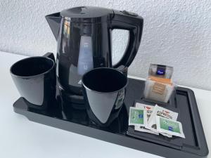 a black coffee maker and two cups on a tray at Vistaflor Cura Marina in Playa del Cura