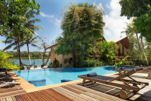een zwembad van het resort met 2 ligstoelen op een terras bij Fatumaru Lodge in Port Vila