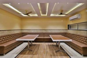 a conference room with brown leather seats and tables at HOTEL CENTRE POINT in Mundra