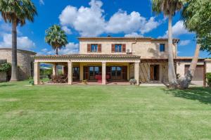 an exterior view of a house with palm trees at Sa Resclosa in Sa Pobla