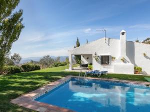 una casa blanca con piscina frente a ella en Belvilla by OYO El Encinar, en La Joya