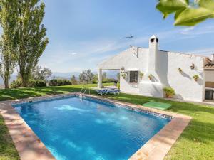 a swimming pool in front of a house at Belvilla by OYO El Encinar in La Joya