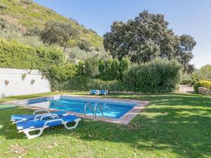 a swimming pool in a yard with two toy boats at Belvilla by OYO El Encinar in La Joya