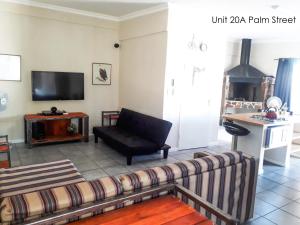 Bateleur Self Catering cc في ويندهوك: غرفة معيشة مع أريكة وتلفزيون