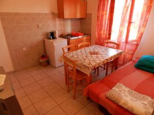 a small kitchen with a table and a room with a bed at Apartments Senny in Orebić +25 photos