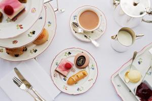 a table with plates of food and a cup of coffee at Hartwell House & Spa in Aylesbury