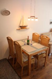 einen Esstisch mit einer Flasche Wein und Stühlen in der Unterkunft Maritime Ferienwohnung in Strandnähe in Dorum Neufeld