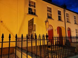 uma cerca preta em frente a um edifício amarelo em Townsend House Guest House em Birr