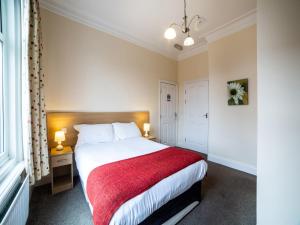 a bedroom with a large bed with a red blanket at The Douglas Hotel in Hartlepool