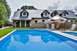 a house with a swimming pool in front of a house at Dwór w Zabużu in Zabuże