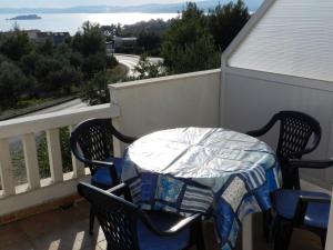 a table and chairs on a balcony with a view of the ocean at Apartments Senny in Orebić