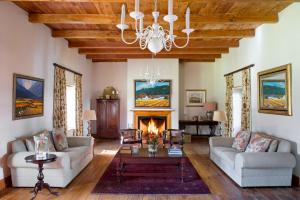 a living room with two couches and a fireplace at Rickety Bridge Manor House in Franschhoek
