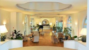 eine Lobby mit Stühlen und Tischen sowie eine Cafeteria in der Unterkunft Hotel Marechiaro in Gizzeria