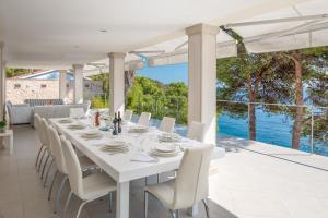 uma sala de jantar branca com uma mesa e cadeiras em Villa Oceanus em Hvar