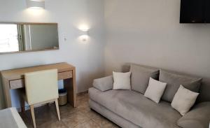 uma sala de estar com um sofá e uma mesa em Hotel Mylos em Firostefani