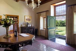 um quarto com uma mesa e uma porta com um vaso de flores em Rickety Bridge Manor House em Franschhoek