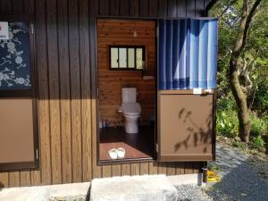 Ochiにあるゲストハウス縁の木造の建物内にバスルーム(トイレ付)があります。