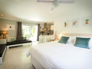a bedroom with a large white bed and a living room at Waterland Lodge in Hout Bay