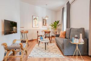 ein Wohnzimmer mit einem Sofa und einem Tisch in der Unterkunft Sweet Inn - Comte Urgell in Barcelona