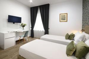 une chambre d'hôtel avec deux lits et un bureau dans l'établissement Napoliseason Rooms & Breakfast, à Naples