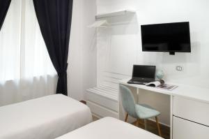 Cette chambre d'hôtel comprend un bureau avec un ordinateur portable et un ordinateur. dans l'établissement Napoliseason Rooms & Breakfast, à Naples
